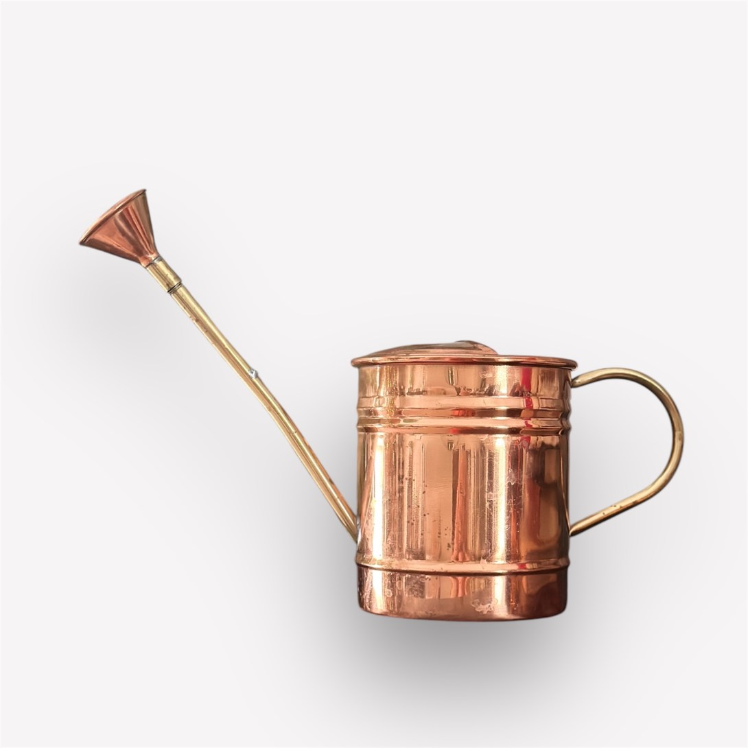 A vintage copper watering can with a long spout and brass handle, set against a white background.